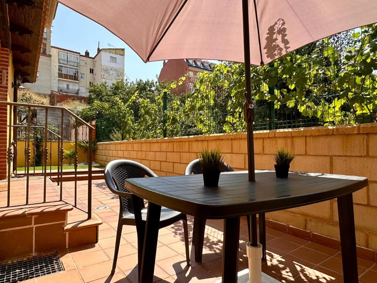 La terraza, con mesa y sombrilla